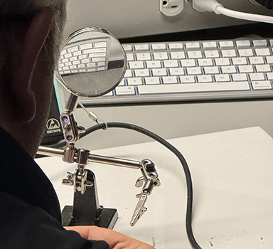 Using the magnifying glass to make sure the application is being applied precisely and to see small details. Which is attached to the helping hands stand. This is meant to hold the wires in a perfect position.      